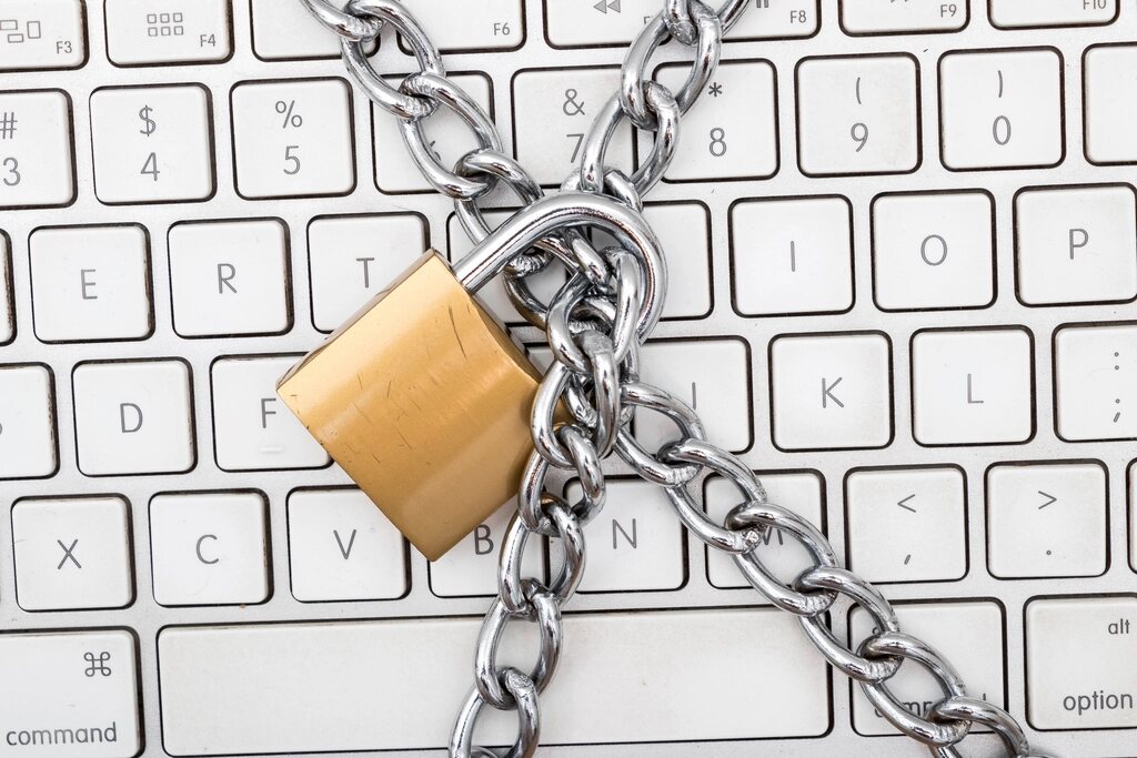 Tastatură de laptop legată cu un lanț și un lacăt