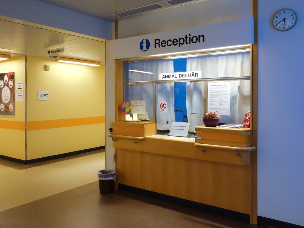 Ghișeul de recepție al unei clinici, cu indicatorul „Reception” deasupra